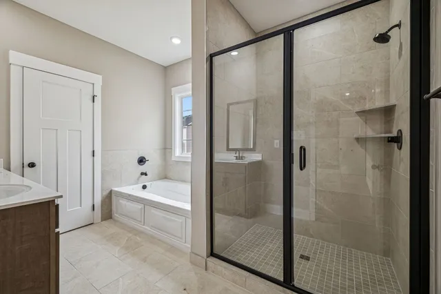 a bathroom with a tub a sink and a large mirror