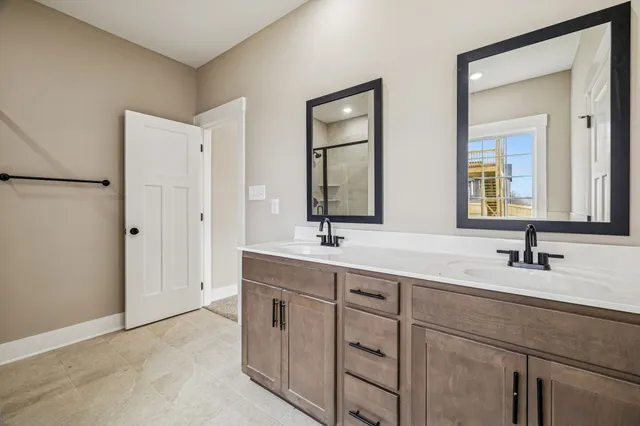a bathroom with double sink and a mirror