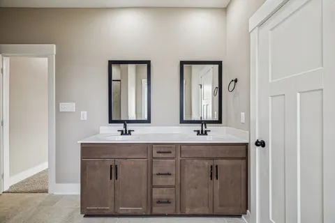 a bathroom with double sink and a mirror