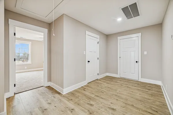 a view of empty room with wooden floor