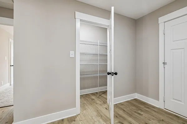 an empty room with windows and fan