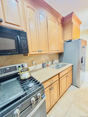a kitchen with stainless steel appliances granite countertop a sink and a refrigerator