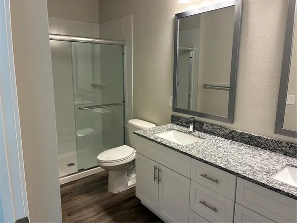 a bathroom with a granite countertop toilet sink and mirror