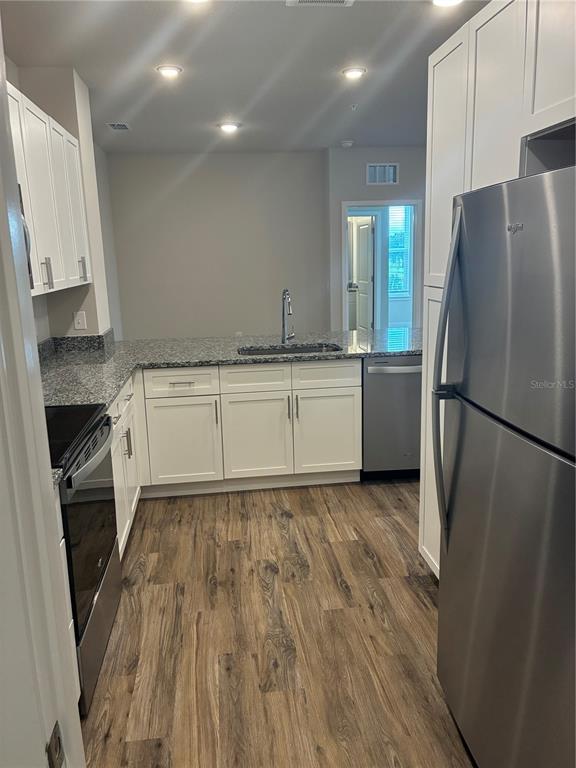 2115 Waterfall Ct Mount, Unit 8211 Mount Dora, FL 32757 - Photo 8 of 21 a kitchen with granite countertop a refrigerator stove and sink