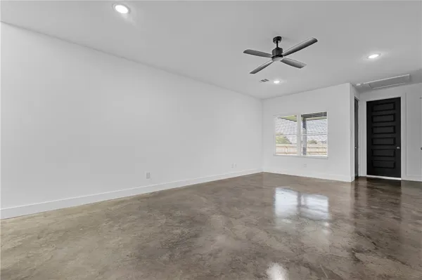 an empty room with wooden floor closet and windows