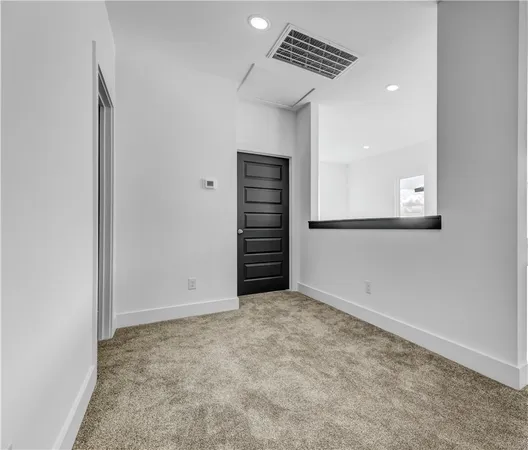 an empty room with a hallway and stairs