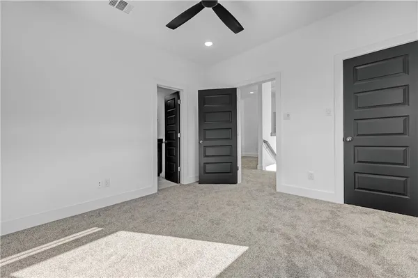 an empty room with closet and ceiling fan