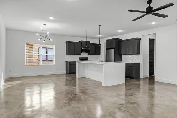 a view of kitchen with kitchen island wooden floor center island and appliances