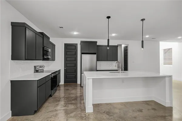 a kitchen with stainless steel appliances a sink and a refrigerator