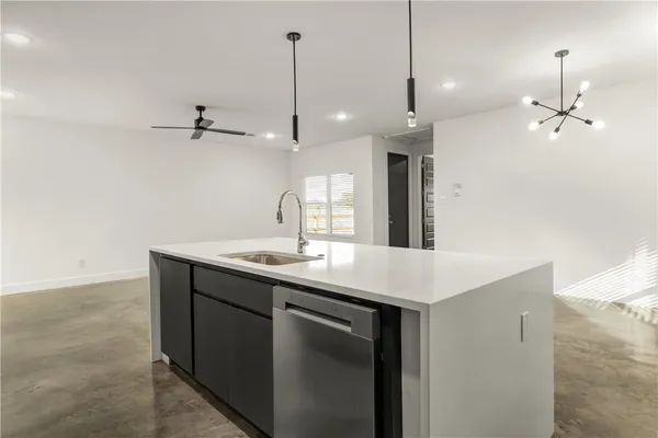 a kitchen with a sink a counter space appliances and cabinets