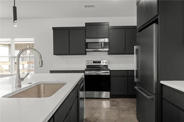 a kitchen with a sink stove and refrigerator