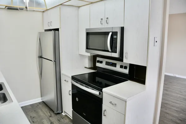a kitchen with stainless steel appliances white cabinets and a stove