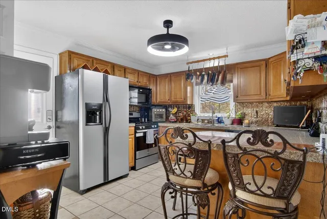 a kitchen with granite countertop a refrigerator stove and sink