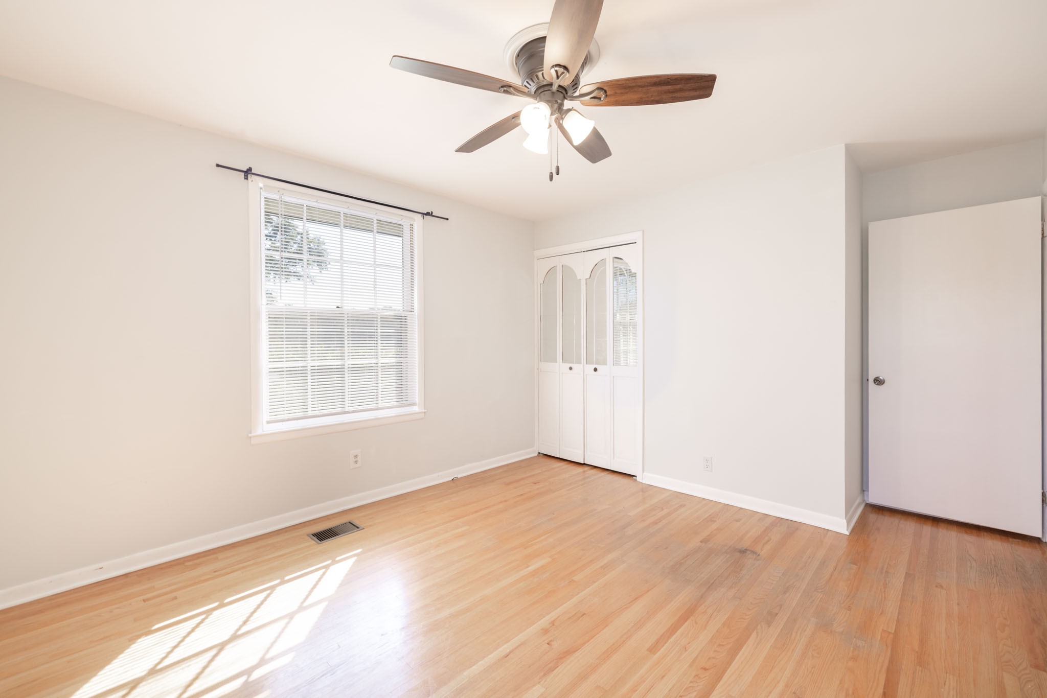 1015 Lockertsville Road Ashland City, TN 37015 - Photo 42 of 72 an empty room with wooden floor fan and windows