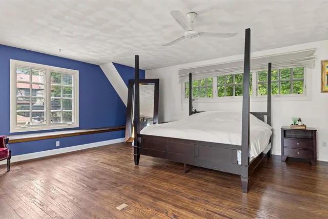 a bed sitting in a spacious bedroom next to a window