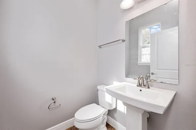 a bathroom with a sink a toilet and mirror