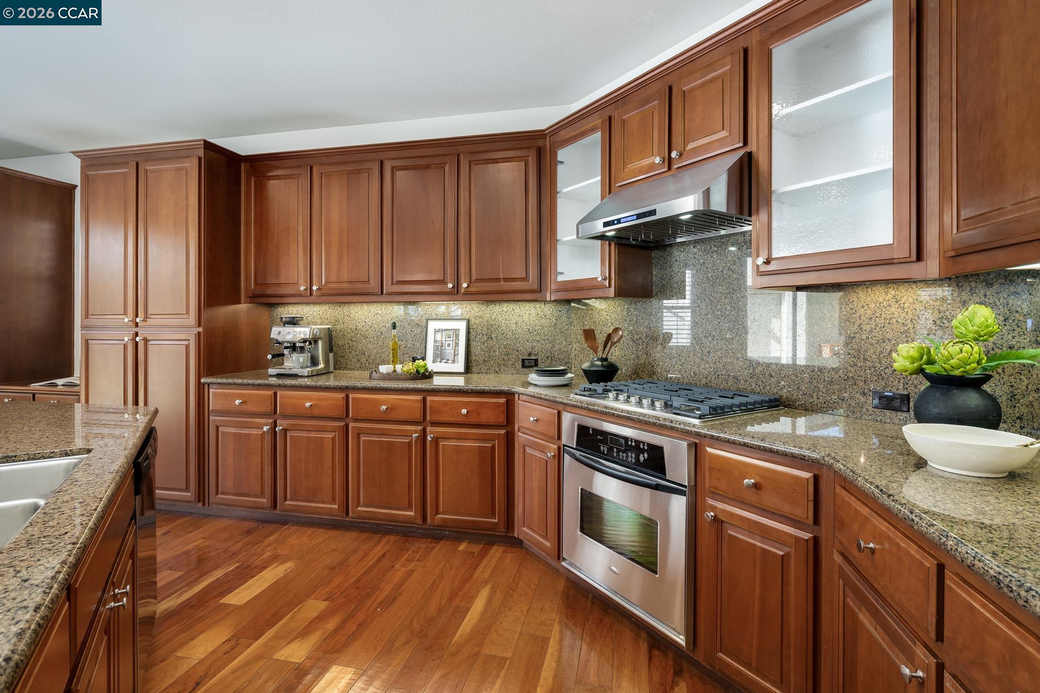2359 Magnolia Bridge Drive San Ramon, CA 94582 - Photo 9 of 44 a kitchen with stainless steel appliances granite countertop a stove a sink dishwasher and microwave oven with wooden cabinets