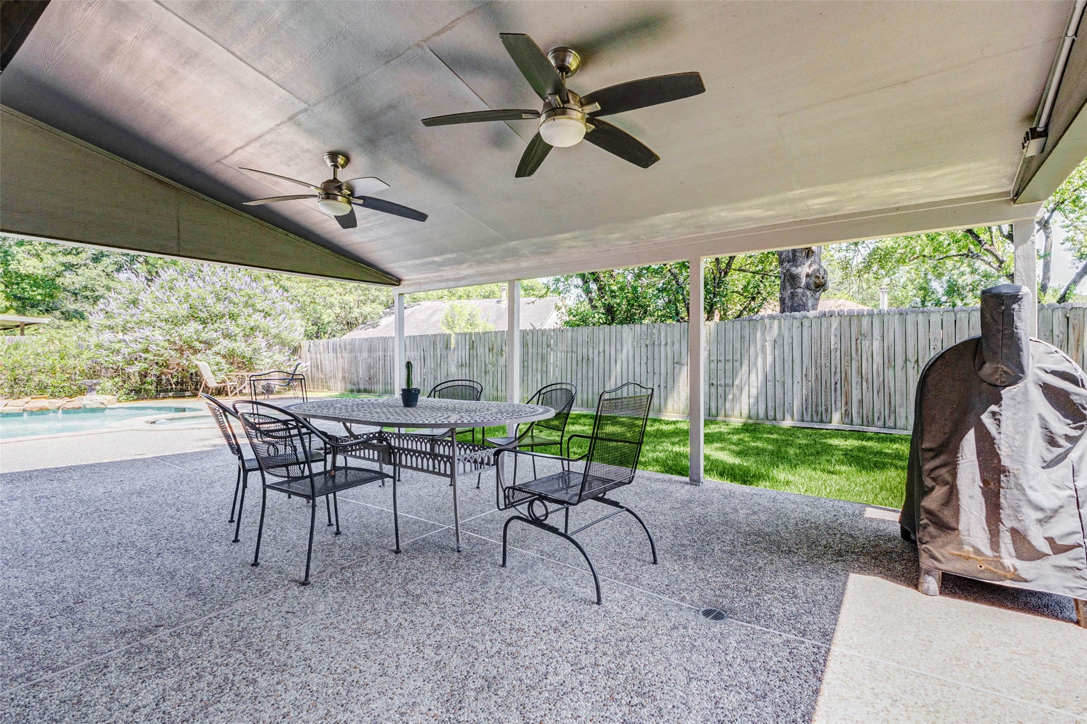 9215 Landry Boulevard Spring, TX 77379 - Photo 34 of 42 Step outside to your expansive covered patio, thoughtfully designed for year round entertaining and relaxation. With ample space for outdoor dining, lounge seating, and grilling, this backyard retreat overlooks the pool and offers the perfect setting for gathering with family and friends.