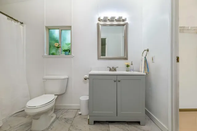 a bathroom with a toilet sink and mirror