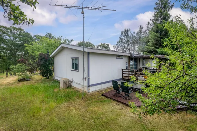 a yellow and white house sitting in middle of the grass
