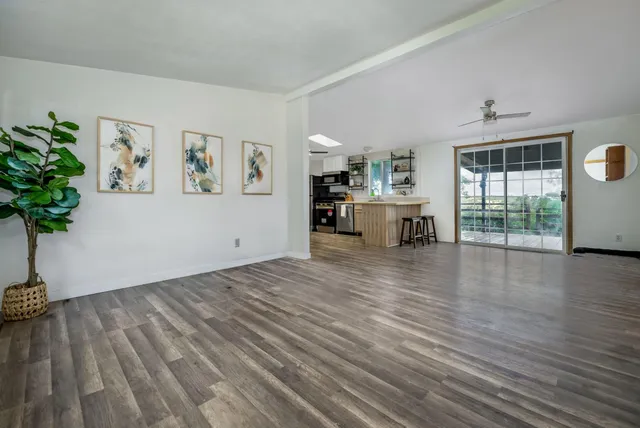 a view of a livingroom with wooden floor and furniture