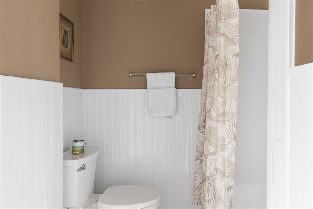 3 Summit Drive, Unit 67 Reading, MA 01867 - Photo 12 of 17 a white toilet sitting next to a shower curtain