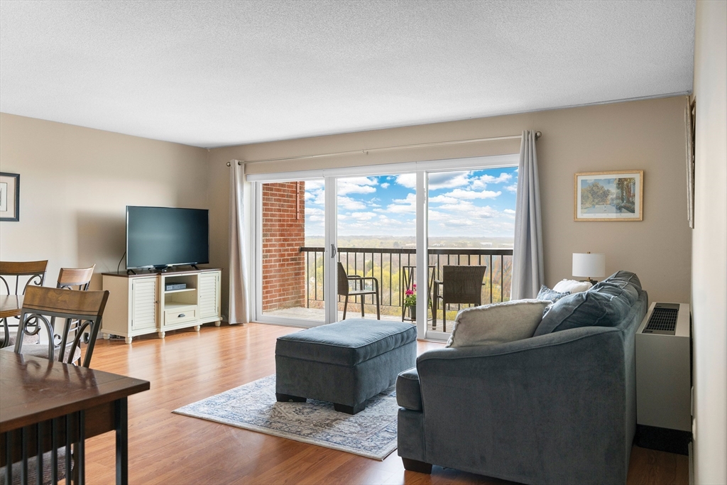 3 Summit Drive, Unit 67 Reading, MA 01867 - Photo 2 of 17 a living room with furniture a flat screen tv and wooden floor