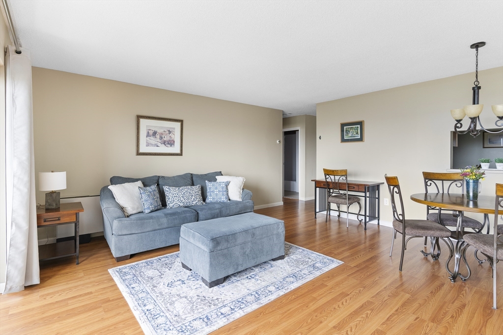 3 Summit Drive, Unit 67 Reading, MA 01867 - Photo 3 of 17 a living room with furniture and a dining table with wooden floor