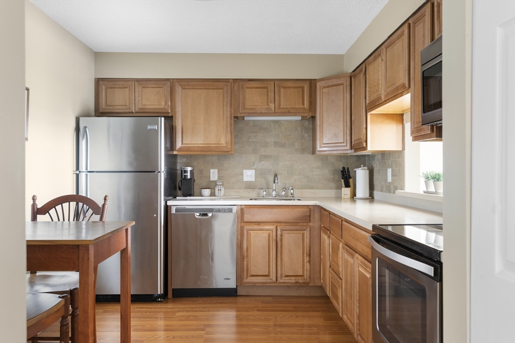 3 Summit Drive, Unit 67 Reading, MA 01867 - Photo 6 of 17 a kitchen with a sink a refrigerator and a stove