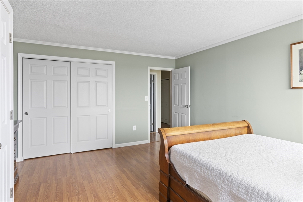 3 Summit Drive, Unit 67 Reading, MA 01867 - Photo 10 of 17 a bedroom with a bed and wooden floor