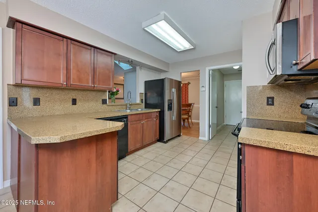 a kitchen with stainless steel appliances granite countertop a sink counter space and a stove top oven