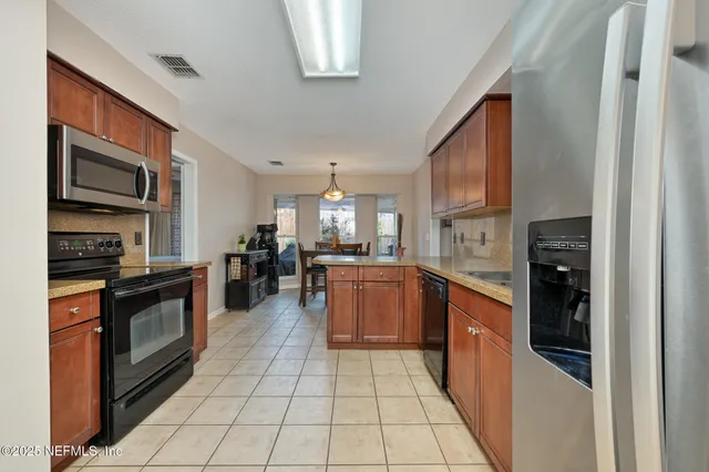 a kitchen with stainless steel appliances granite countertop a refrigerator and a stove top oven