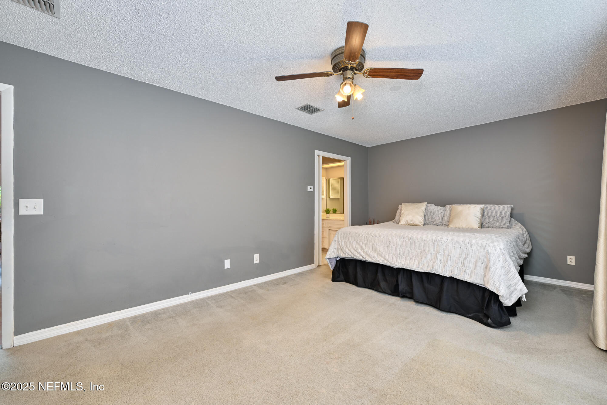 10905 Brentfield Road Jacksonville, FL 32225 - Photo 19 of 36 a spacious bedroom with a bed and a ceiling fan