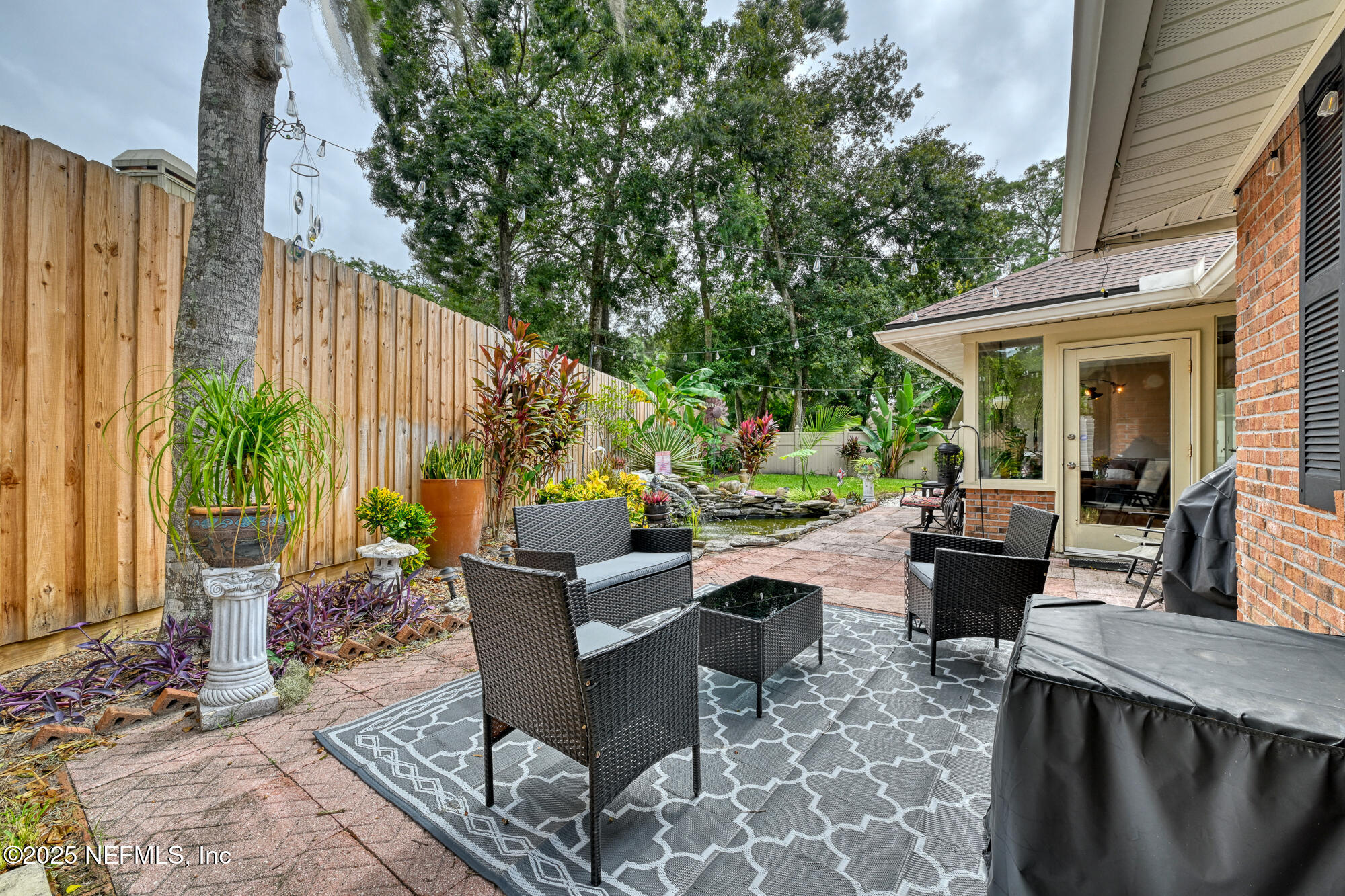 10905 Brentfield Road Jacksonville, FL 32225 - Photo 31 of 36 a view of a patio with table and chairs potted plants with wooden floor and fence