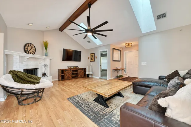 a living room with furniture a flat screen tv and a fireplace