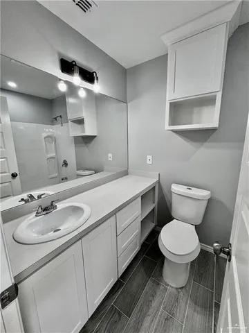 a bathroom with a sink toilet and a mirror