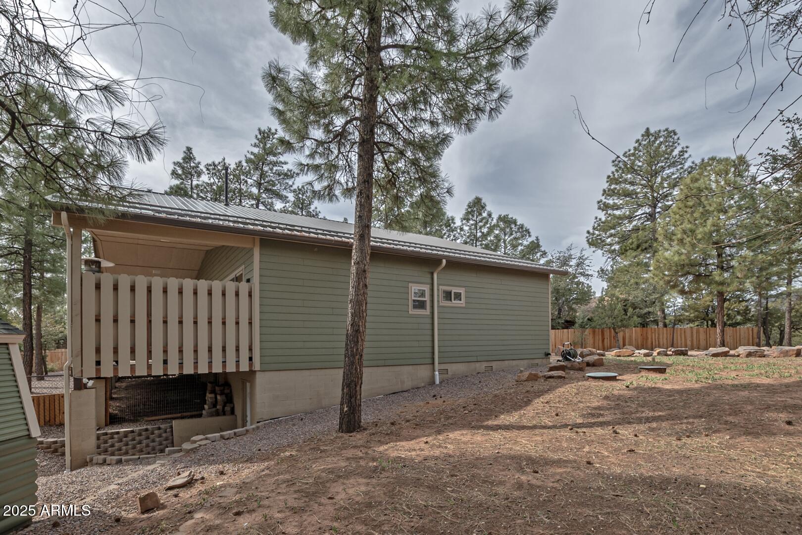 3465 Whispering Pines Road Pine, AZ 85544 - Photo 41 of 53 a backyard of a house with a tree and fence