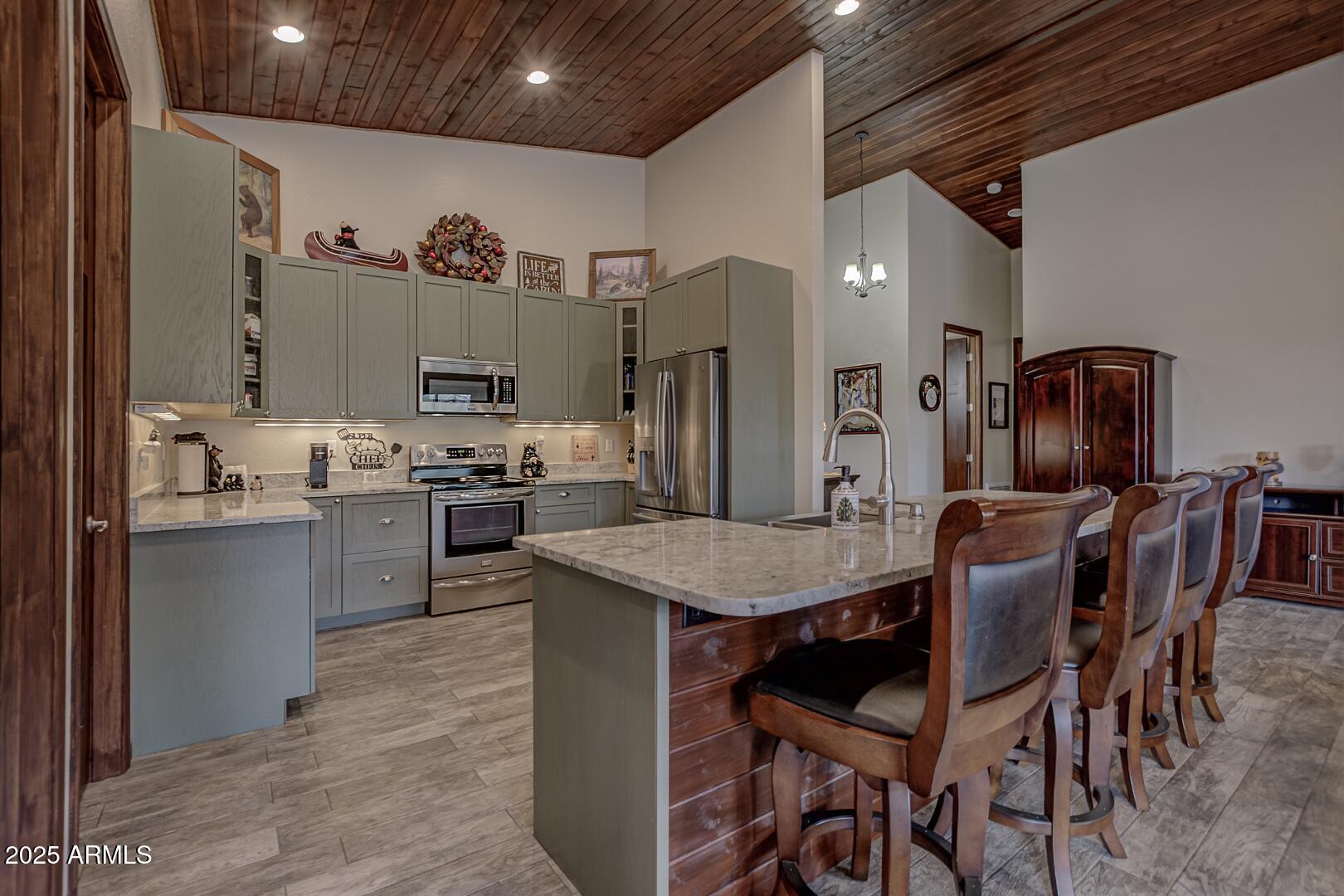 3465 Whispering Pines Road Pine, AZ 85544 - Photo 9 of 53 a dining room with stainless steel appliances kitchen island granite countertop a table chairs and a refrigerator