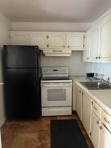 a kitchen with white cabinets and white appliances
