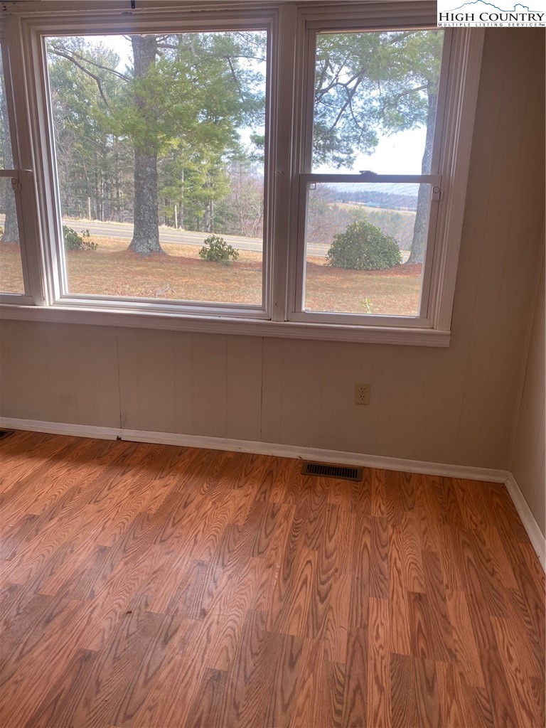 1345 Wagoner Ridge Road Ennice, NC 28623 - Photo 18 of 48 a view of an empty room with wooden floor and a window