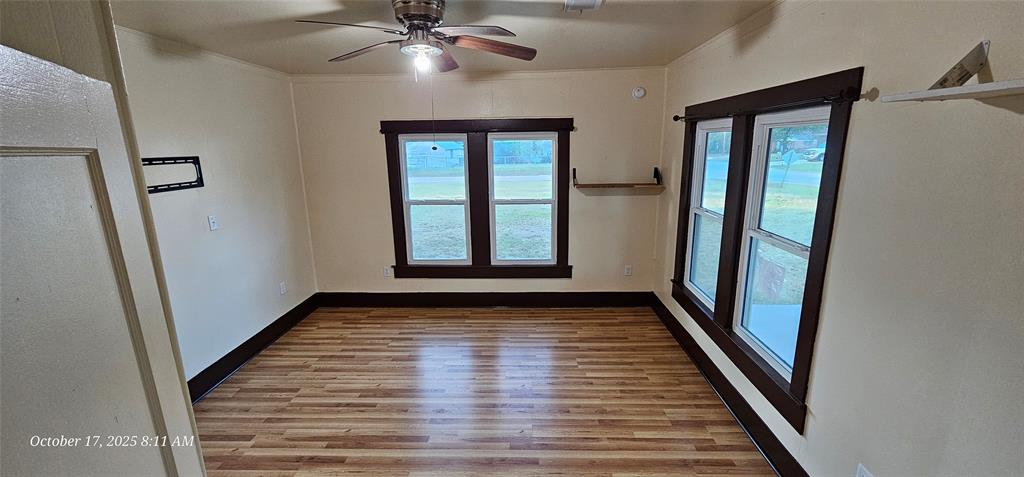 407 Pecan Street Clyde, TX 79510 - Photo 13 of 40 an empty room with wooden floor and staircase