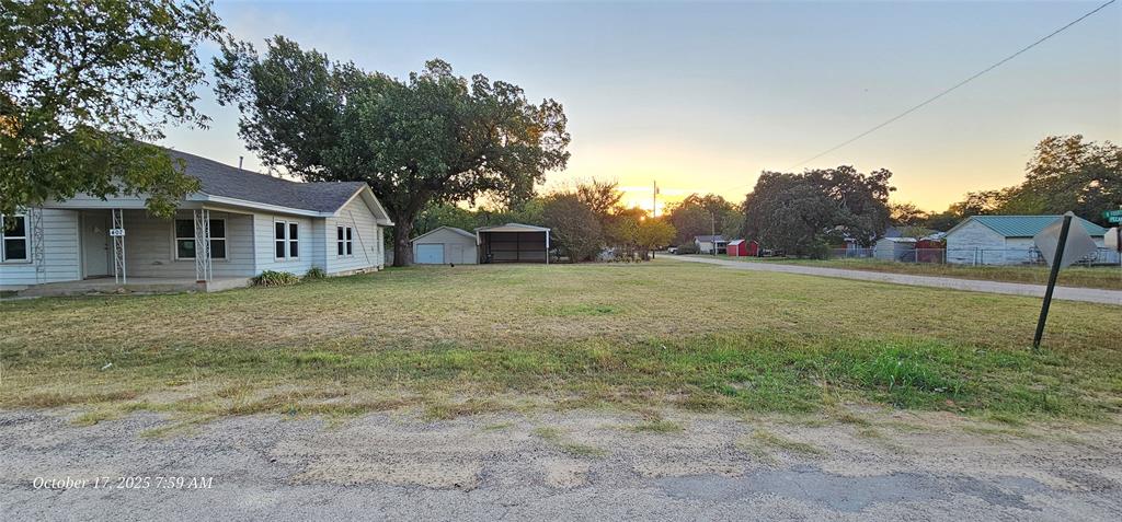 407 Pecan Street Clyde, TX 79510 - Photo 5 of 40 a view of a yard in front of a house with a large tree