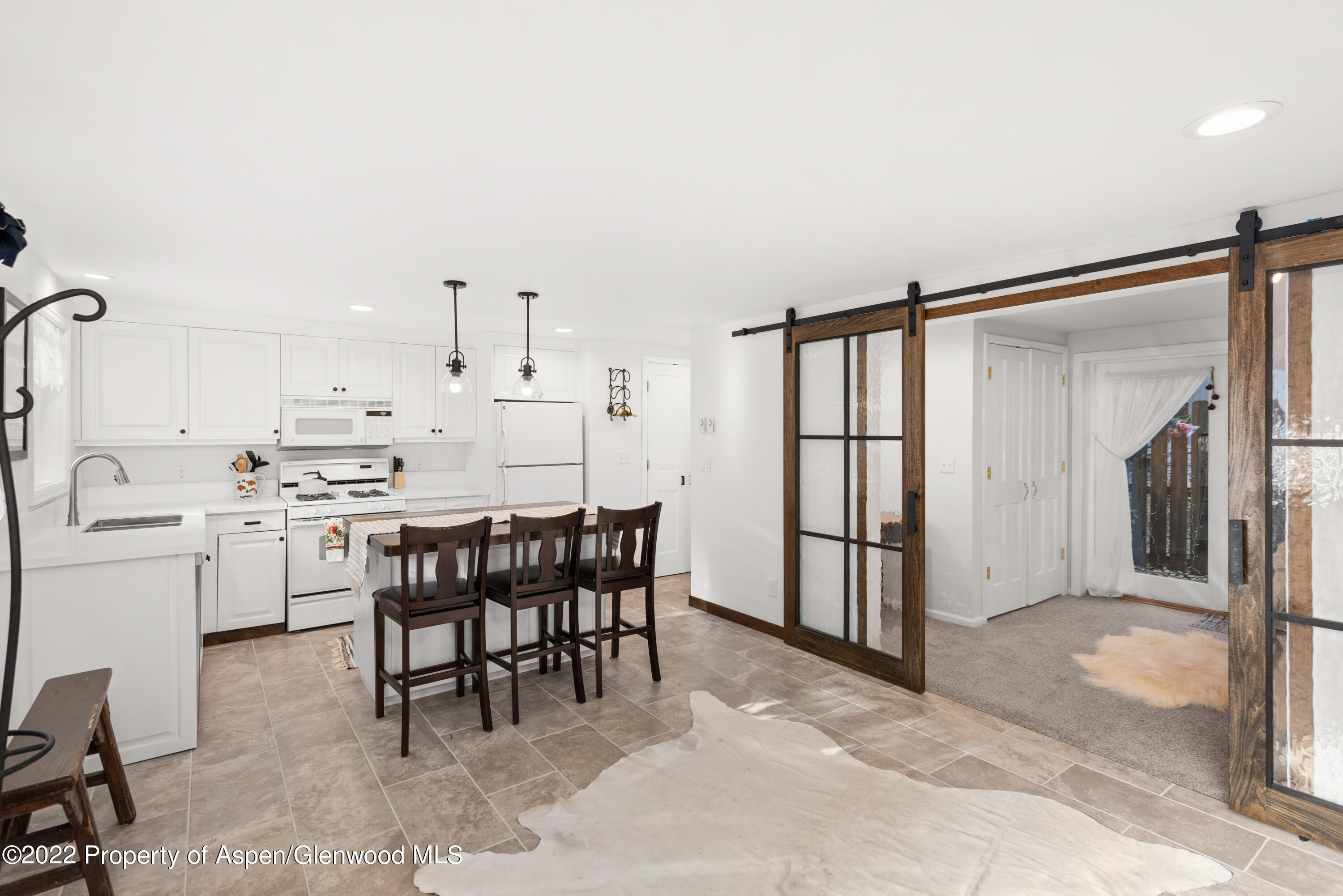 950 East Durant Avenue, Unit 2 Aspen, CO 81611 - Photo 8 of 14 a kitchen with kitchen island a table and chairs in it