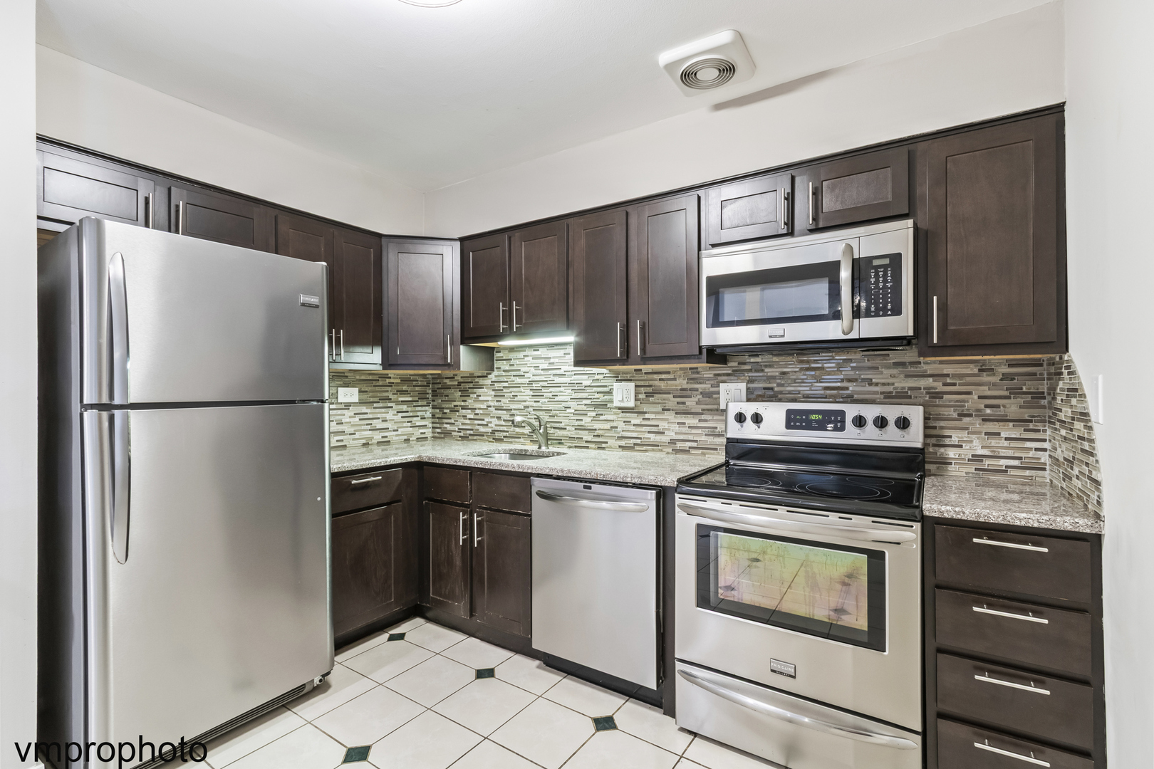 2323 South Goebbert Road, Unit F109 Arlington Heights, IL 60005 - Photo 2 of 11 a kitchen with a refrigerator stove and microwave
