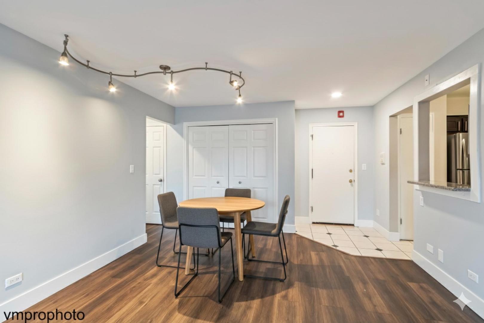 2323 South Goebbert Road, Unit F109 Arlington Heights, IL 60005 - Photo 3 of 11 a view of a dining room with furniture and wooden floor