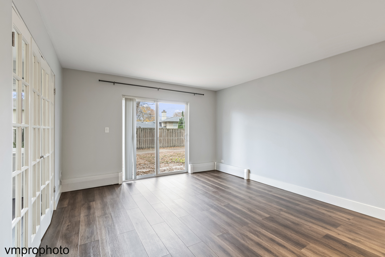 2323 South Goebbert Road, Unit F109 Arlington Heights, IL 60005 - Photo 5 of 11 a view of an empty room with wooden floor and a window