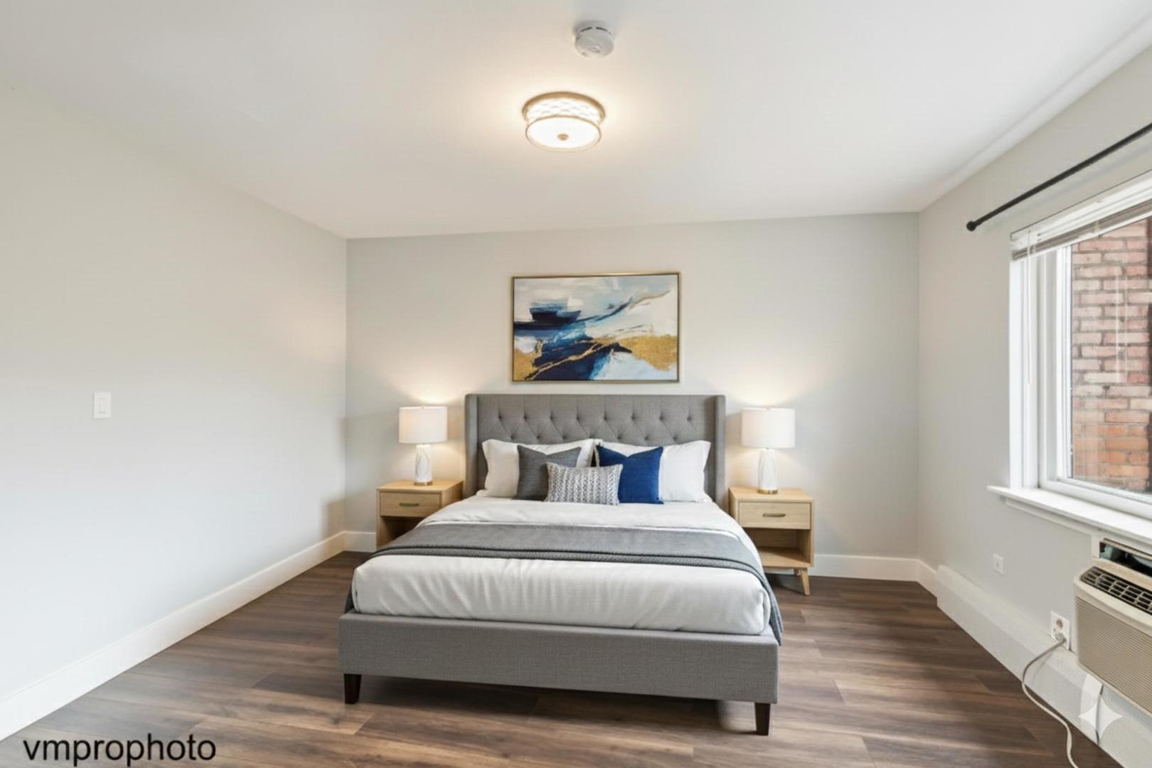 2323 South Goebbert Road, Unit F109 Arlington Heights, IL 60005 - Photo 8 of 11 a bedroom with a bed and wooden floor