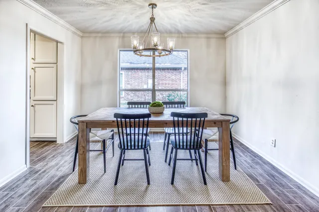 a dining room with furniture a chandelier and wooden floor