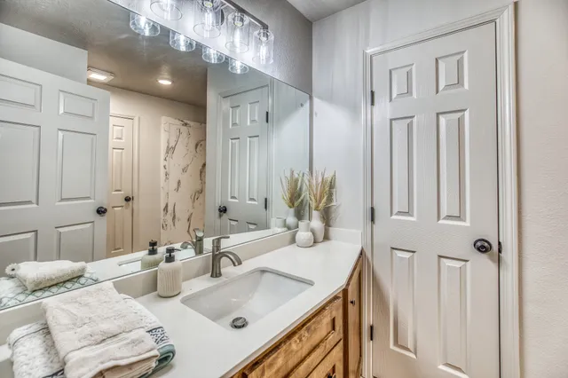 a bathroom with double vanity sink and a mirror