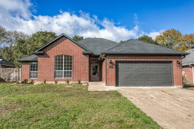 a front view of a house with a garden and yard